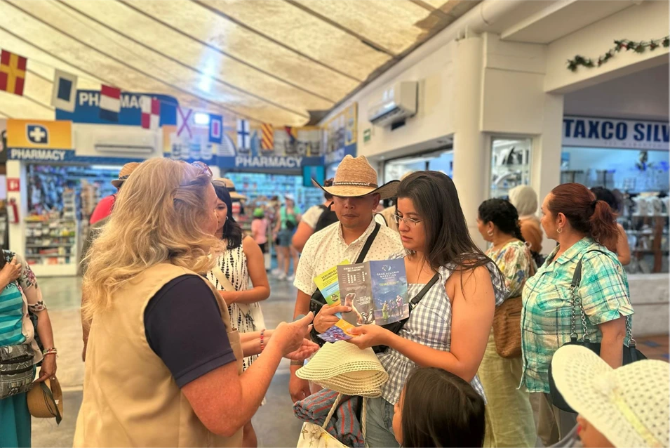 Cruise passengers look through Gran Acuario Mazatlán brochures